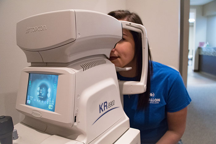 patient getting her vision tested with autorefractor